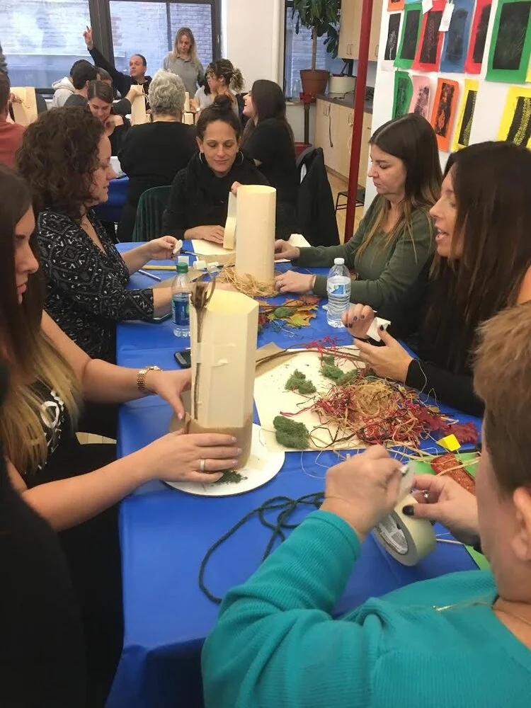 Educators building sculptures from paper, card and found materials at a workshop table
