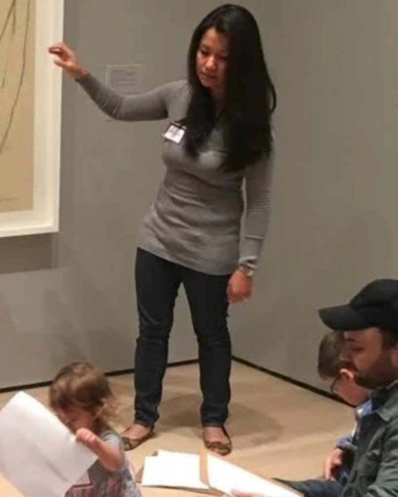 Wan Ling Fahrer standing beside a large drawing, gesturing toward it while teaching
